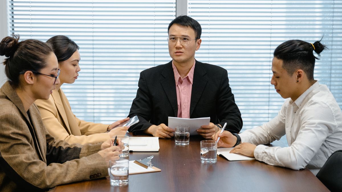 Directors and shareholders meeting around a boardroom table at a Thai company annual general meeting